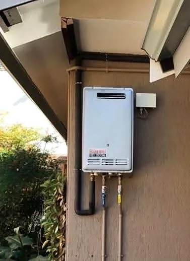 Gas water heater mounted on a face-brick wall