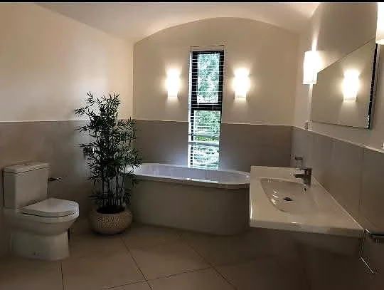 Renovated bathroom with corner bath and basin