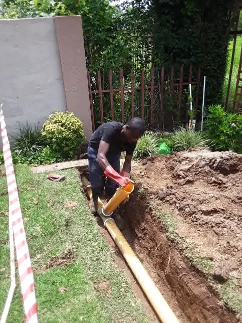 Trench being dug to reach underground pipework