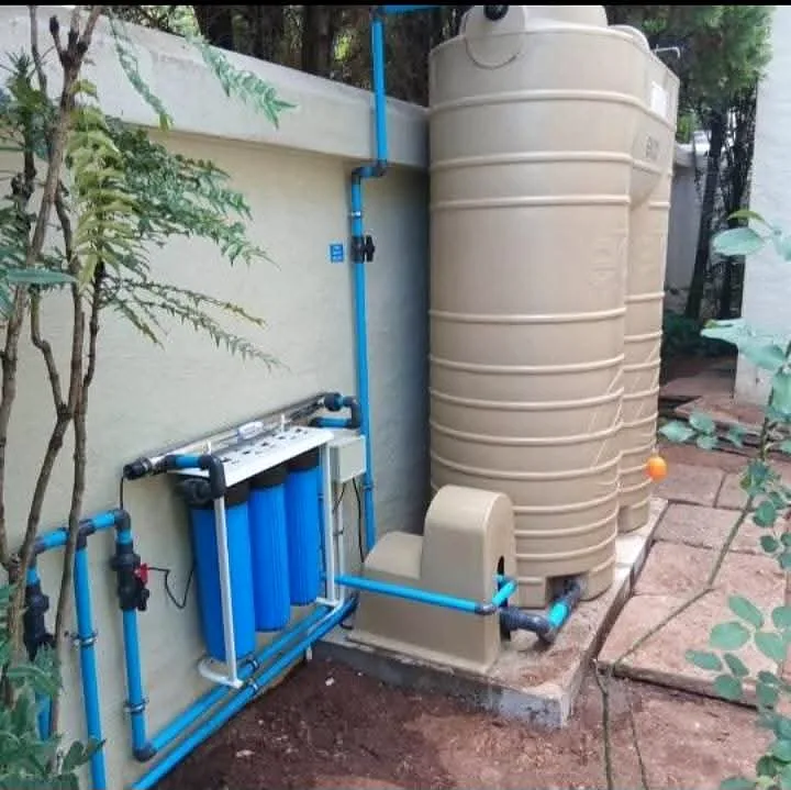 Water tank with filter housings and connecting pipework