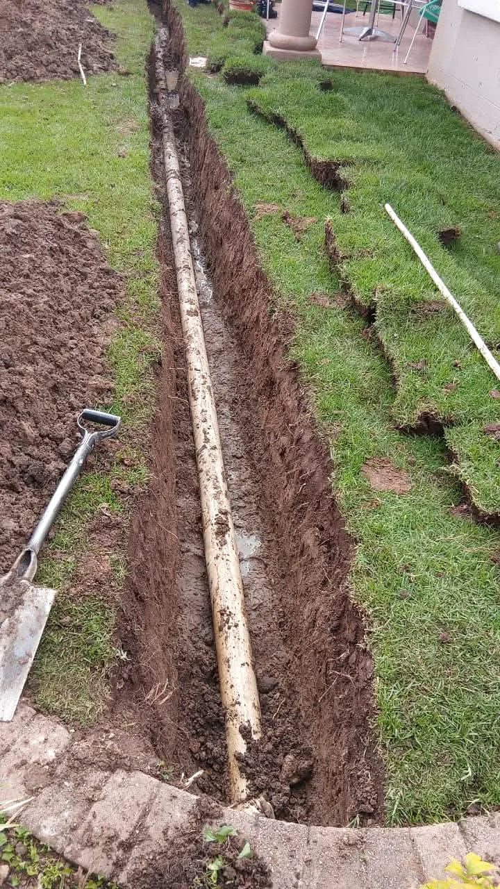 Trench dug across a lawn for a new underground water line