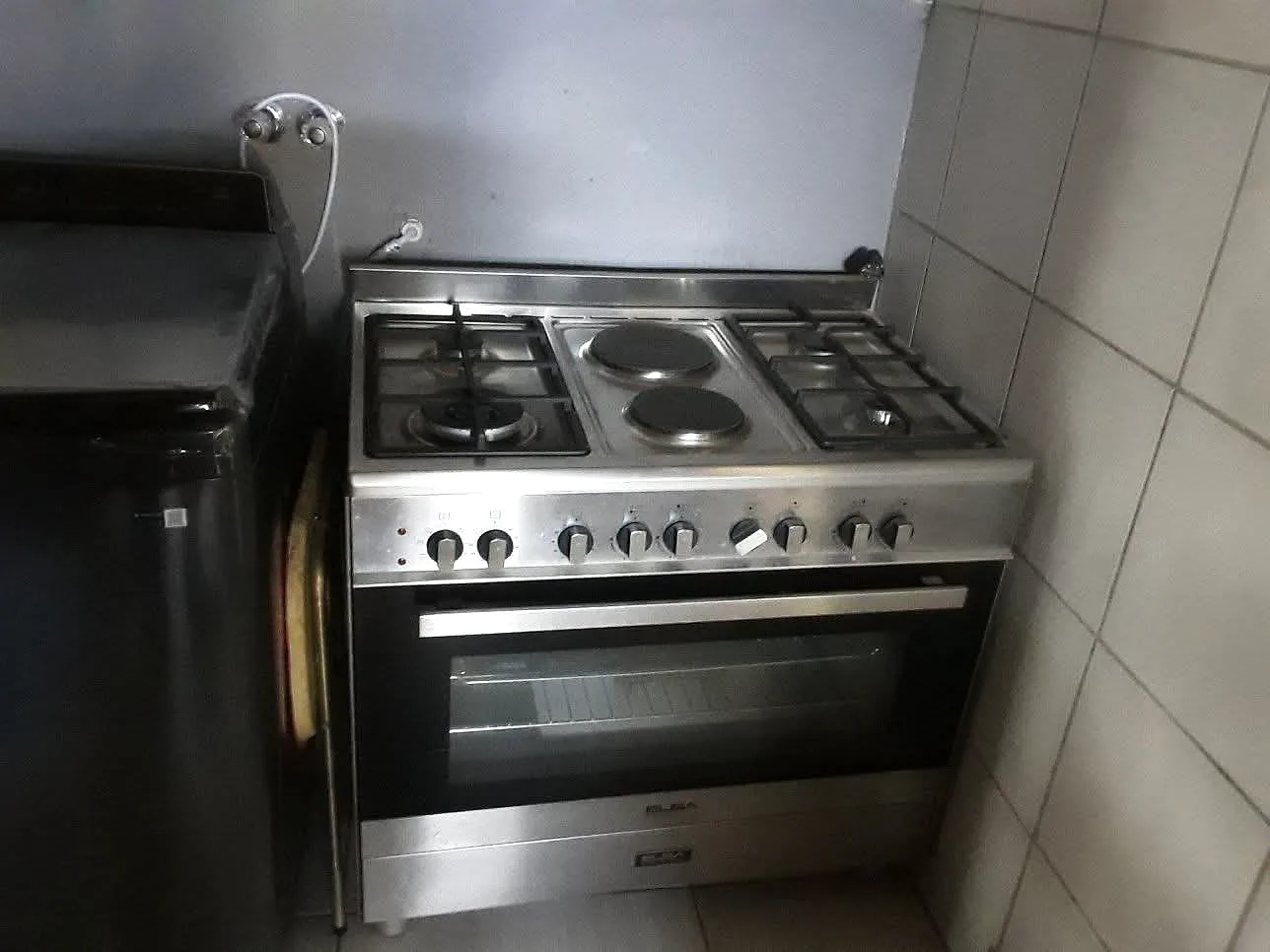 Freestanding gas range installed in a tiled kitchen