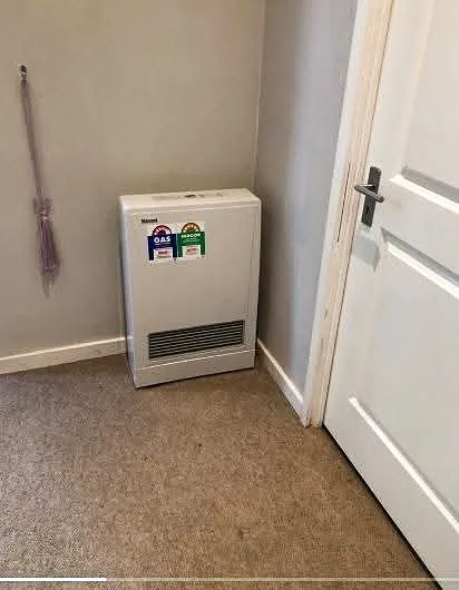 Gas heater installed against an interior wall