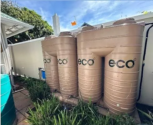 Four ECO water storage tanks installed alongside a house