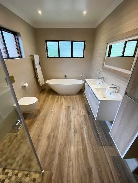 Renovated bathroom with freestanding bath and vanities