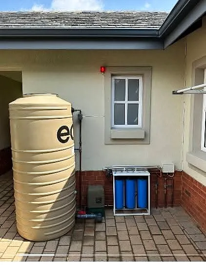 Green water storage tanks installed along a boundary wall